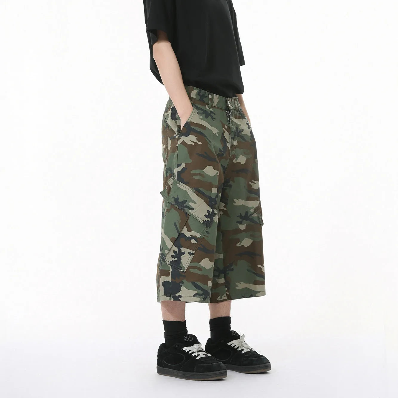 Men's camouflage-coloured cotton jeans with wide loose legs, cropped length, and side pockets on a plain background.