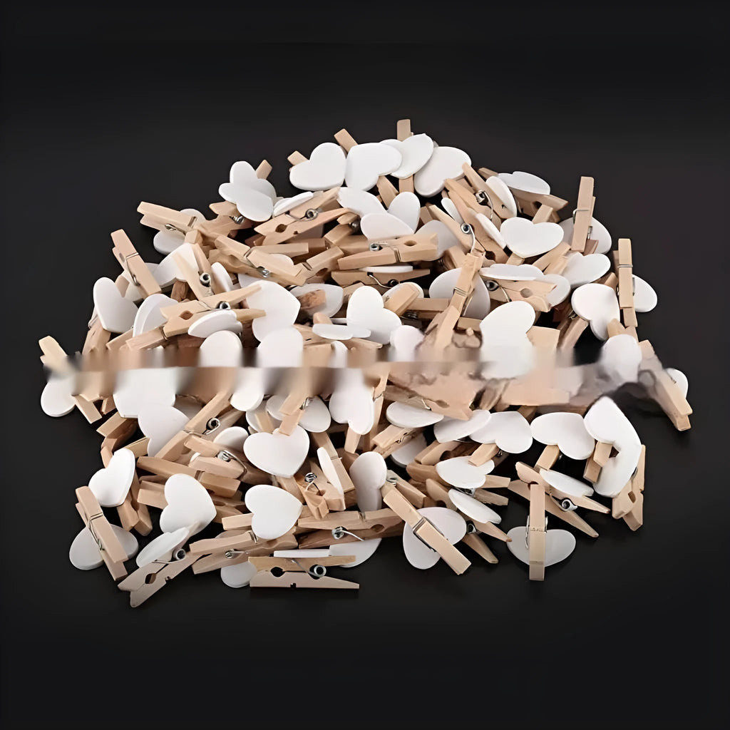 A set of five handmade wooden heart-shaped clips in assorted colours on a plain background.