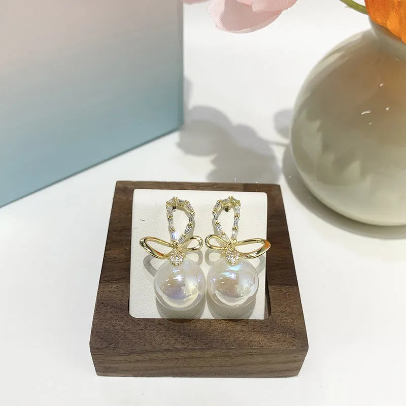 Pair of minimalist mermaid pearl earrings, each with a freshwater pearl drop on a gold-tone fish hook fitting, Style1