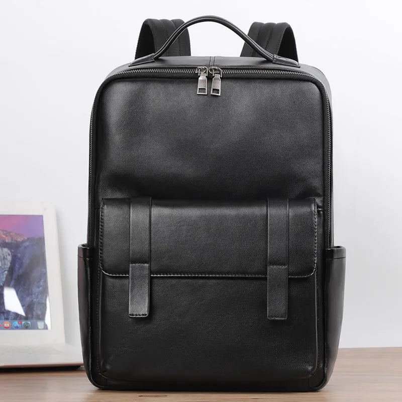 Men's black genuine leather computer backpack with curved back plate showing litchi grain texture and substantial 36-55L capacity.