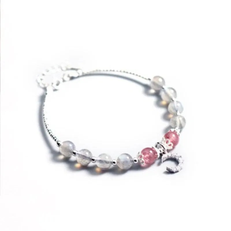 Handmade silver-toned bracelet with a blue-grey 6mm moonstone bead, small crescent moon charm, and clear crystal on an adjustable chain.