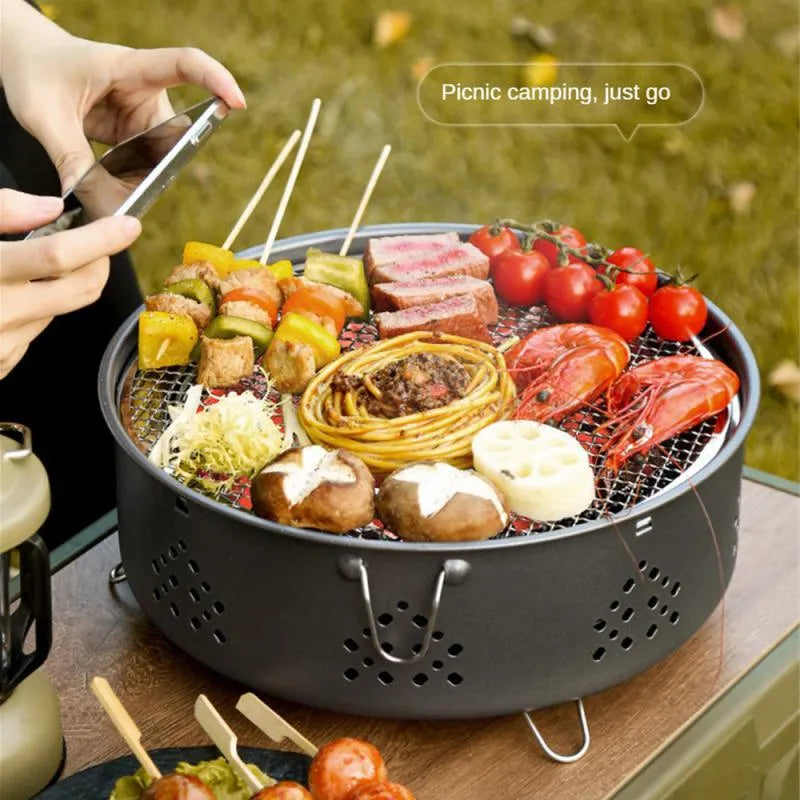 Portable stainless steel charcoal barbecue grill with removable legs and storage bag for outdoor use.