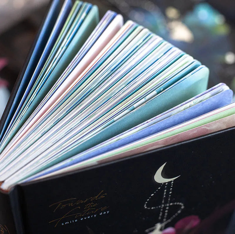 A5 diary notebook with luminous holographic cover open to show pages with colour illustrations.