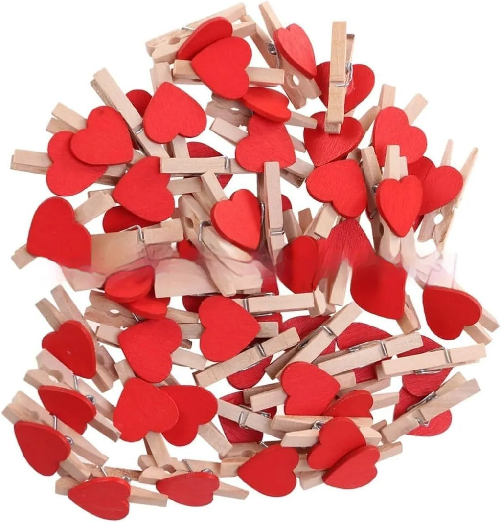 A set of five handmade wooden heart-shaped clips in assorted colours on a plain background.