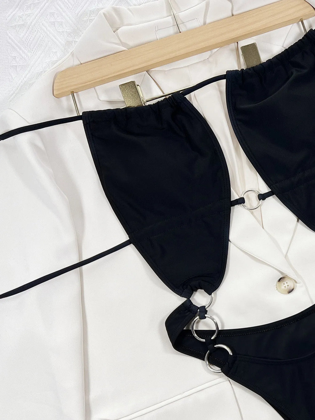 Black solid colour sleeveless one-piece swimsuit for women on a hanger.