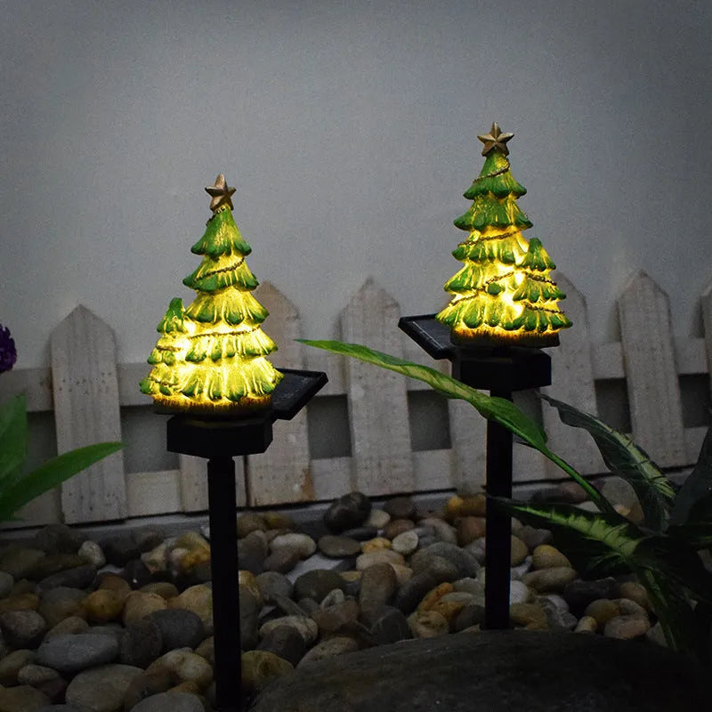 Solar Christmas tree ground plug light with warm white LED, resin body and 40 x 40mm solar panel for outdoor garden use.