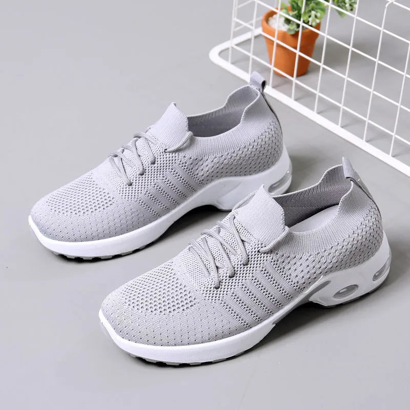 Women's solid colour mesh sneaker with round toe and white PVC sole on a grey background