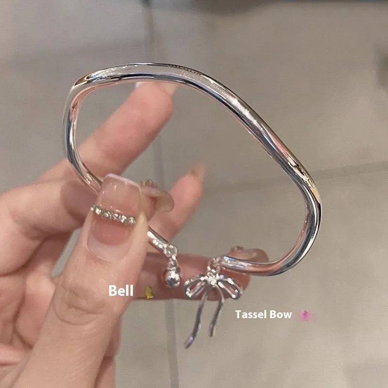 Silver adjustable bracelet with bow charm and opening bell clasp