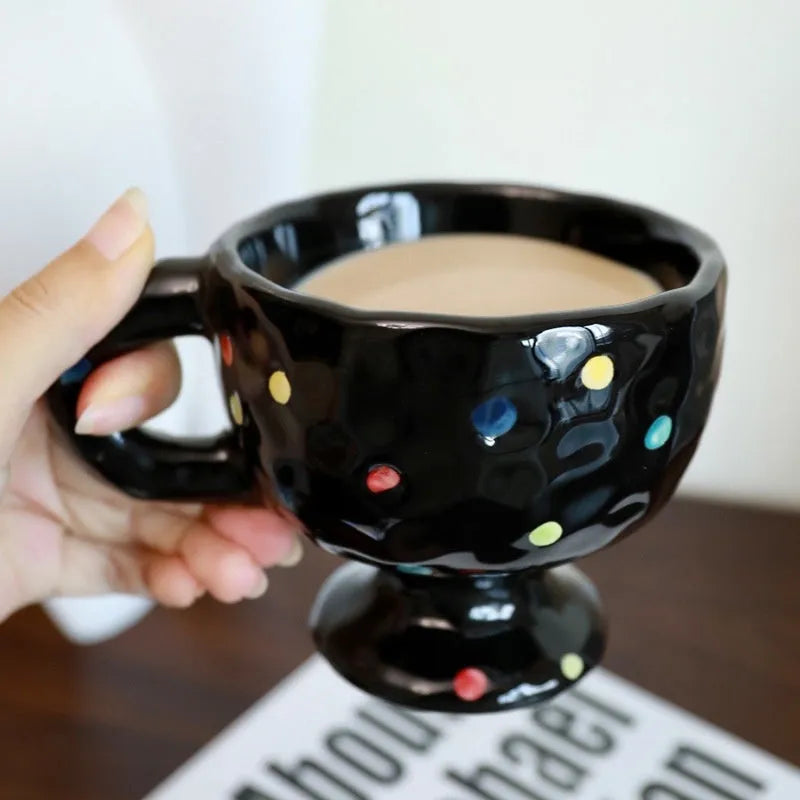 Hand-pinched irregular shaped solid colour ceramic mug on a table, showing its unique form and modern simplicity design.