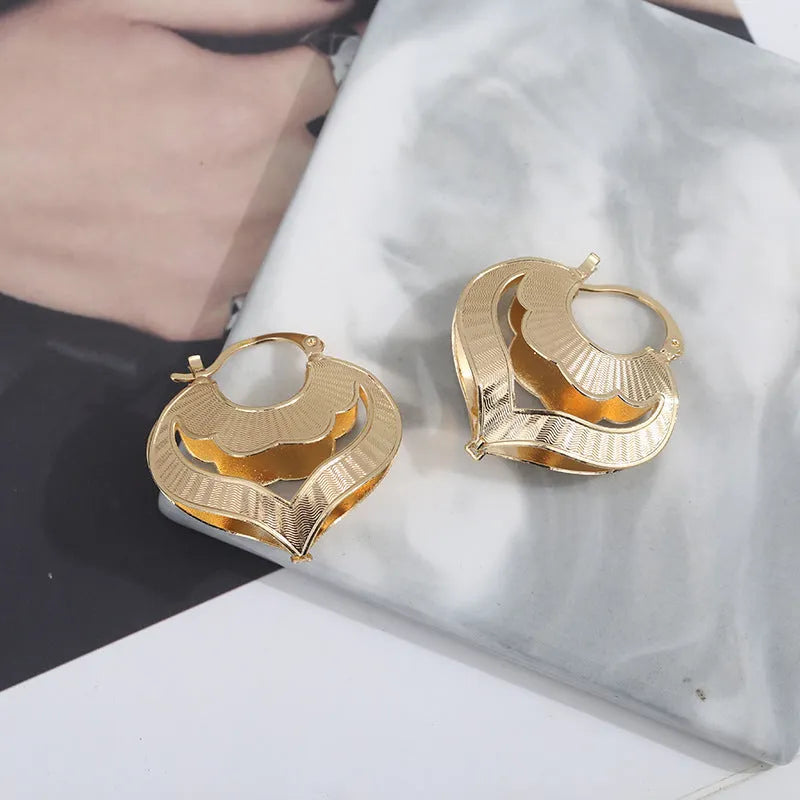 Gold electroplated copper heart-shaped hollow stud earrings with lace-inspired openwork design and geometric round elements