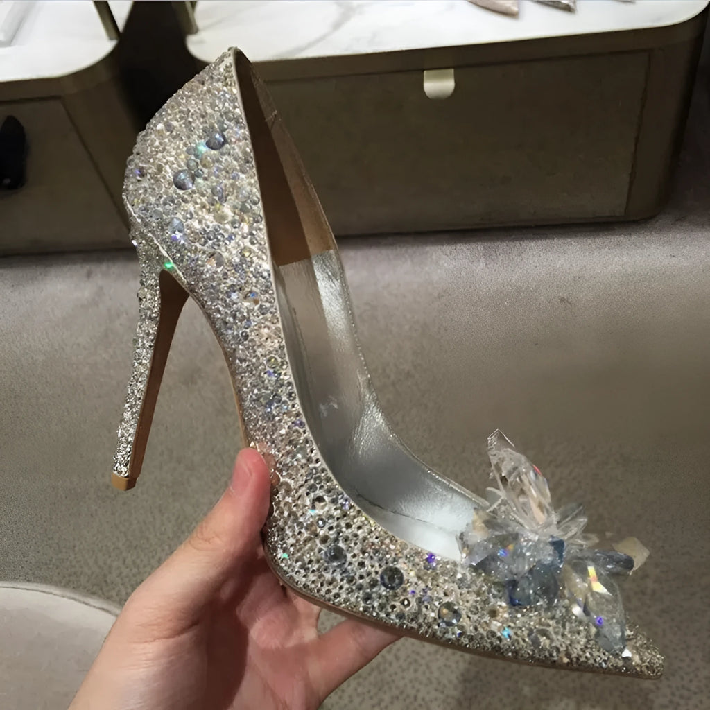 Gold women's pointed toe high heels with rhinestone and bow decoration on a stiletto heel.