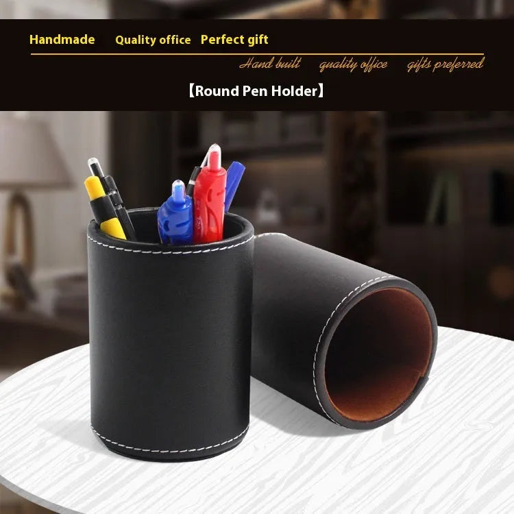 Small round black leather pen container on desk with pens inside