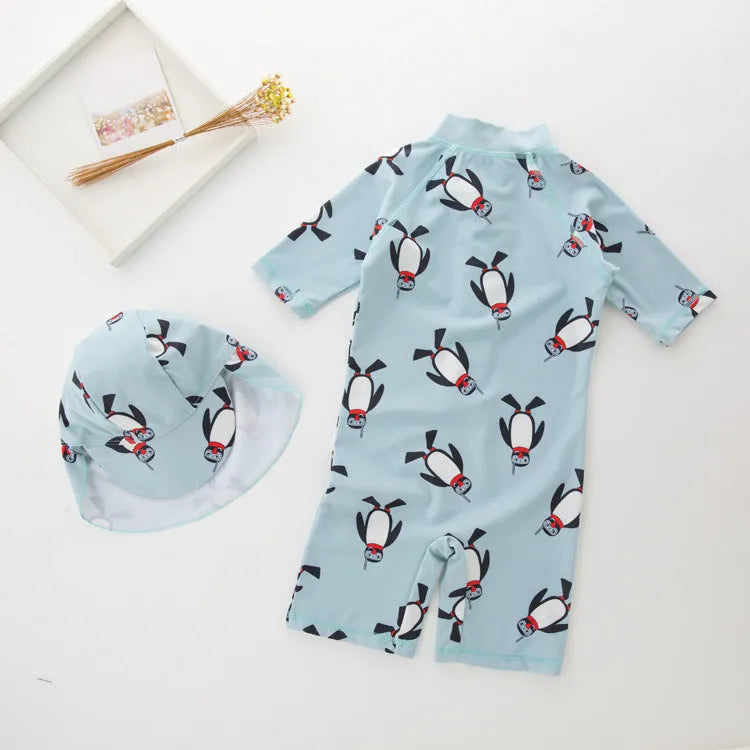 Boy's penguin print long sleeve one-piece swimsuit with matching swimming cap.