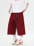 Black wide leg denim shorts with multiple pockets and cropped length on a mannequin