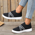 Black women's flat shoes with flyknit mesh upper, round toe, tassel detail, and rubber sole.