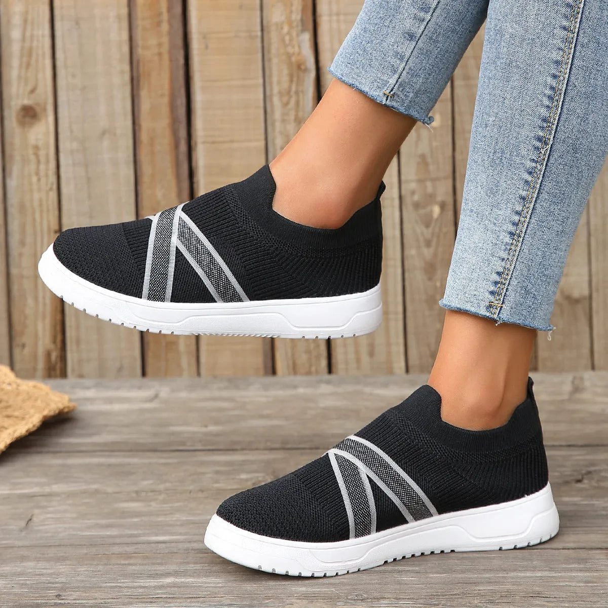 Black women's flat shoes with flyknit mesh upper, round toe, tassel detail, and rubber sole.