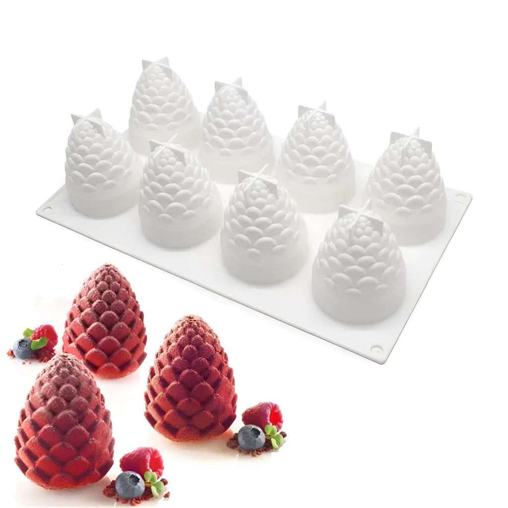 Silicone baking mould with six cavities shaped like pineapples, pine cones, and pears on a kitchen worktop.
