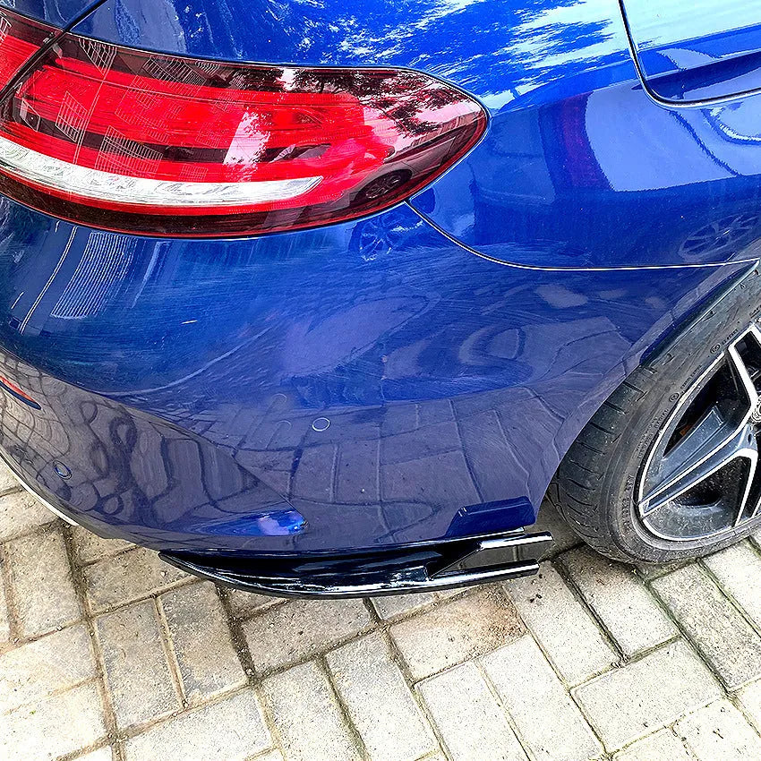 Pair of car rear bumper corner protectors in carbon fibre pattern on a vehicle rear corner