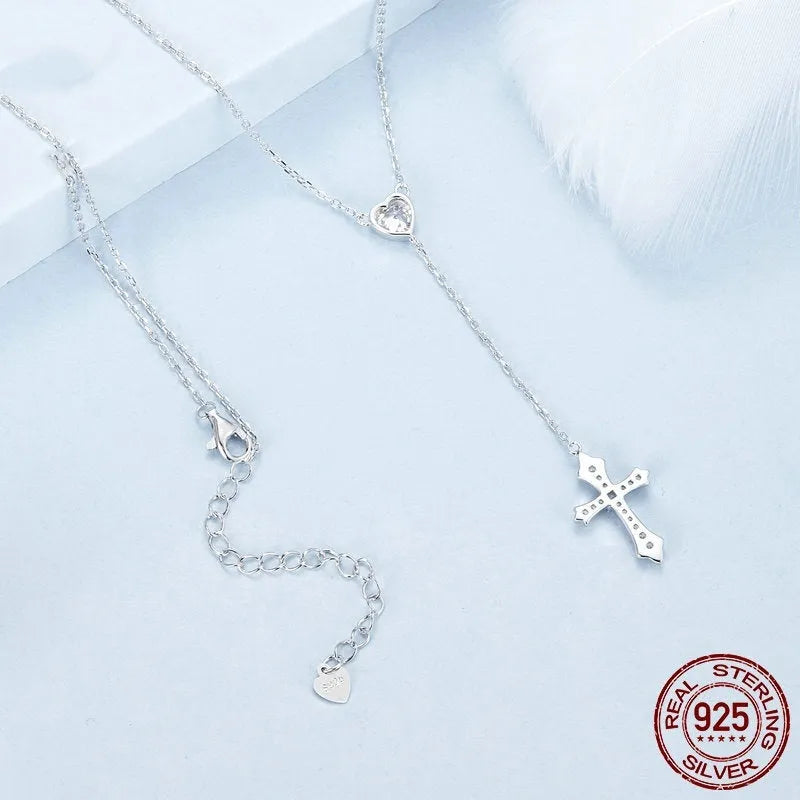 Simple silver love cross necklace on a V-neck O-ring chain for women.