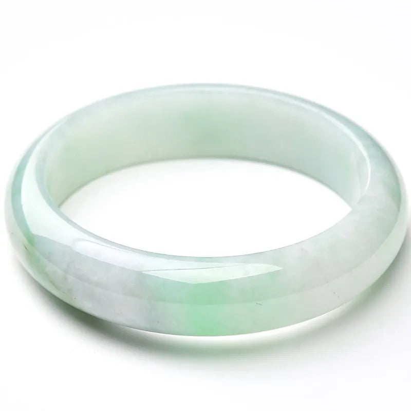 Light green jade bracelet showing natural stone colouration with size markings from 53 to 64
