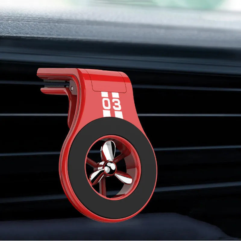 Black magnetic car phone holder clipped to car air vent with smartphone attached and fragrance pads