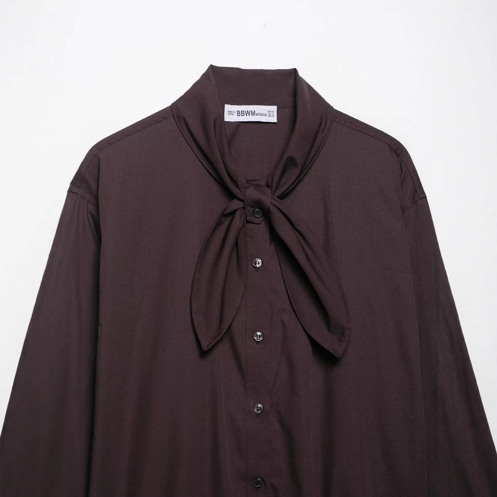 Brown women's long sleeve poplin shirt with a bow tie, shown in a loose cardigan style.
