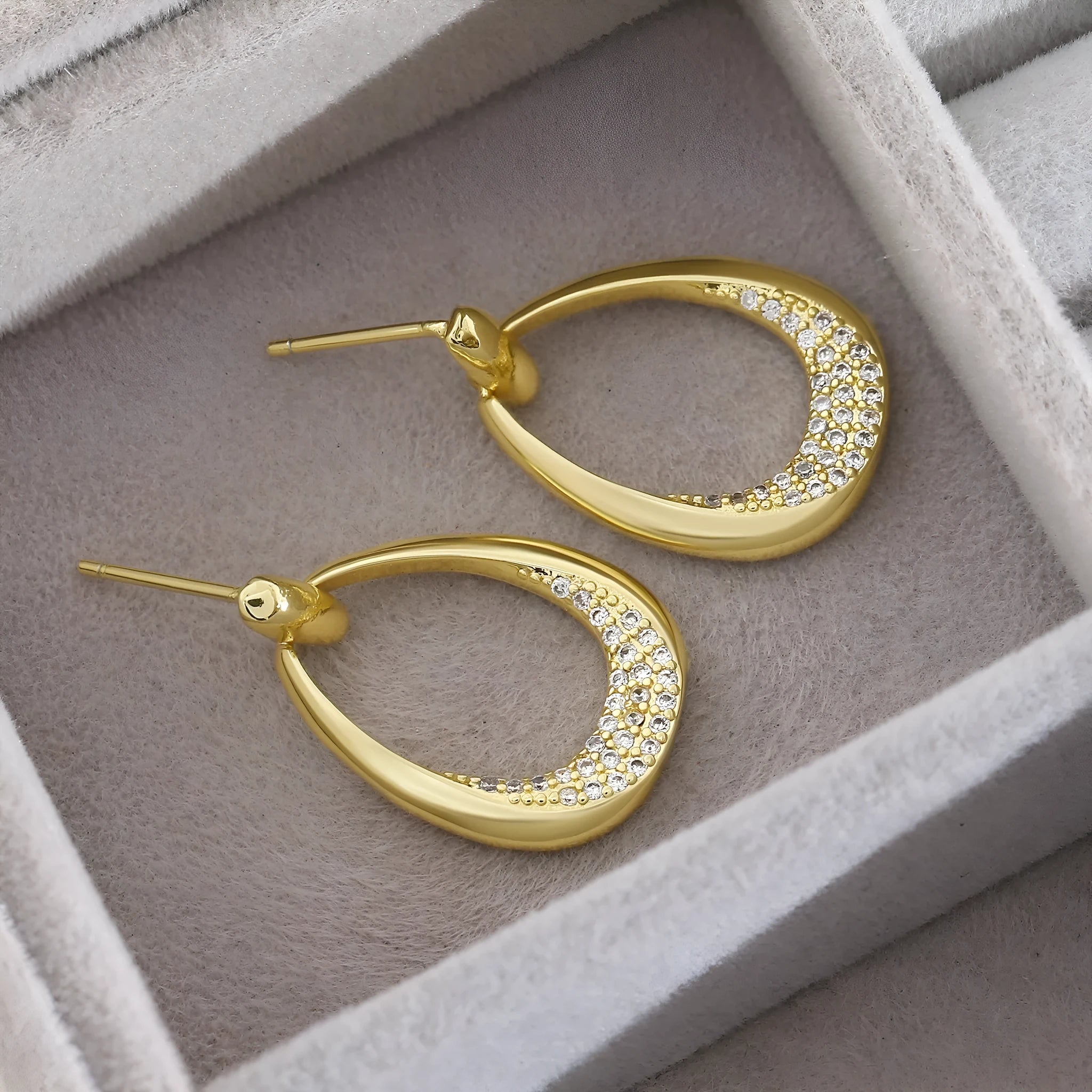 Yellow gold geometric drop-shaped women's earrings with round and oval design elements.