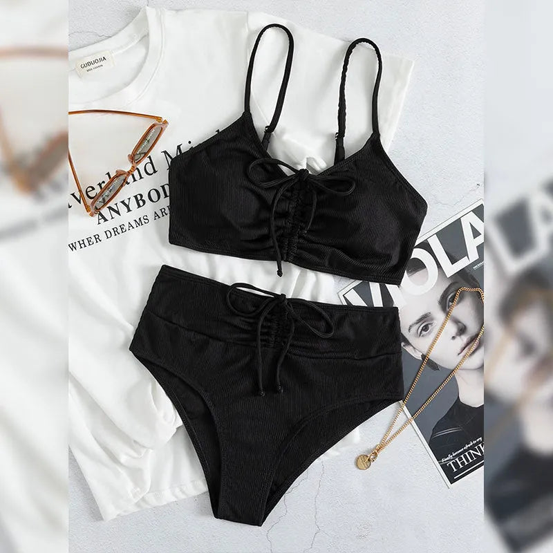 Black women's bikini swimsuit with sling split style and high waist shorts.