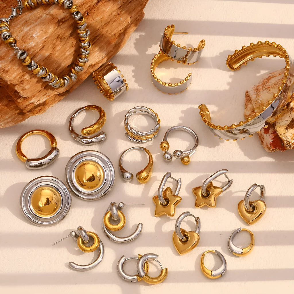 Women's stainless steel jewellery set with gold electroplated finish showing earrings, bracelet and necklace with geometric designs