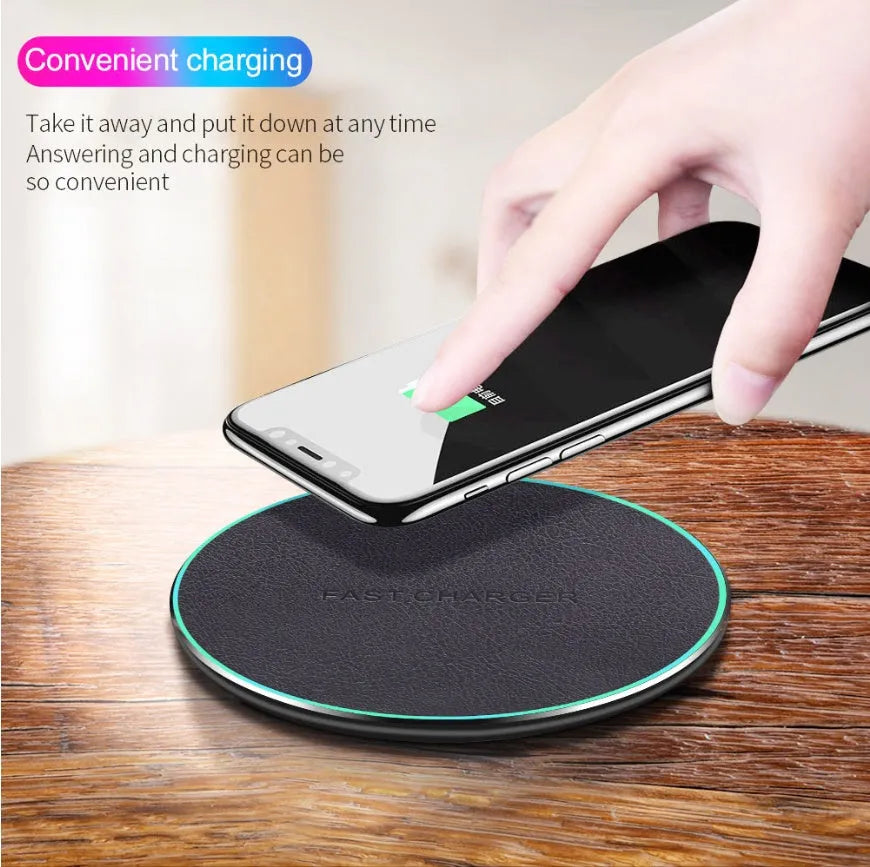 Black Quick Qi wireless charging pad on a desk, compatible with iPhone 11.