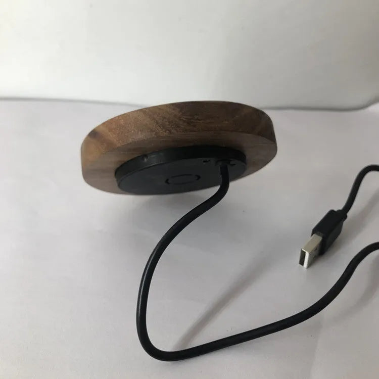 Black round 60mm diameter wireless phone charger for embedding into desk or table surface.