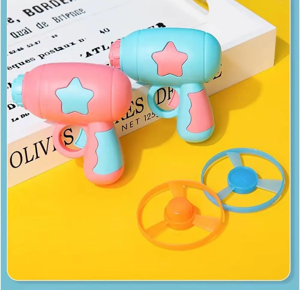 Blue plastic interactive cat toy gun with a mounted pink Frisbee on a table.