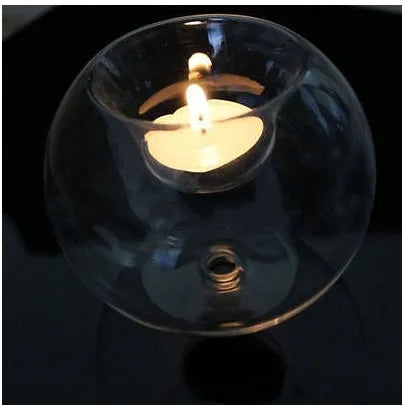 Handmade transparent round hollow glass candle holder for a tealight on a wooden table