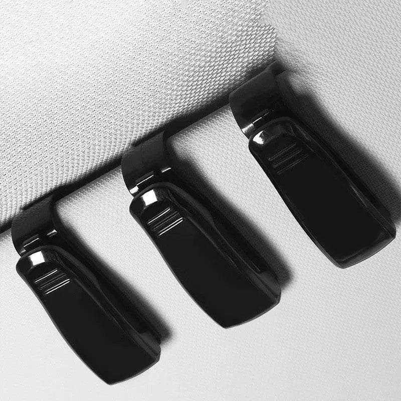 Black plastic clip for car sunshade holding sunglasses and an ID card