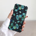 Black silicone iPhone case featuring a printed leaf design, shown fitted to a phone.