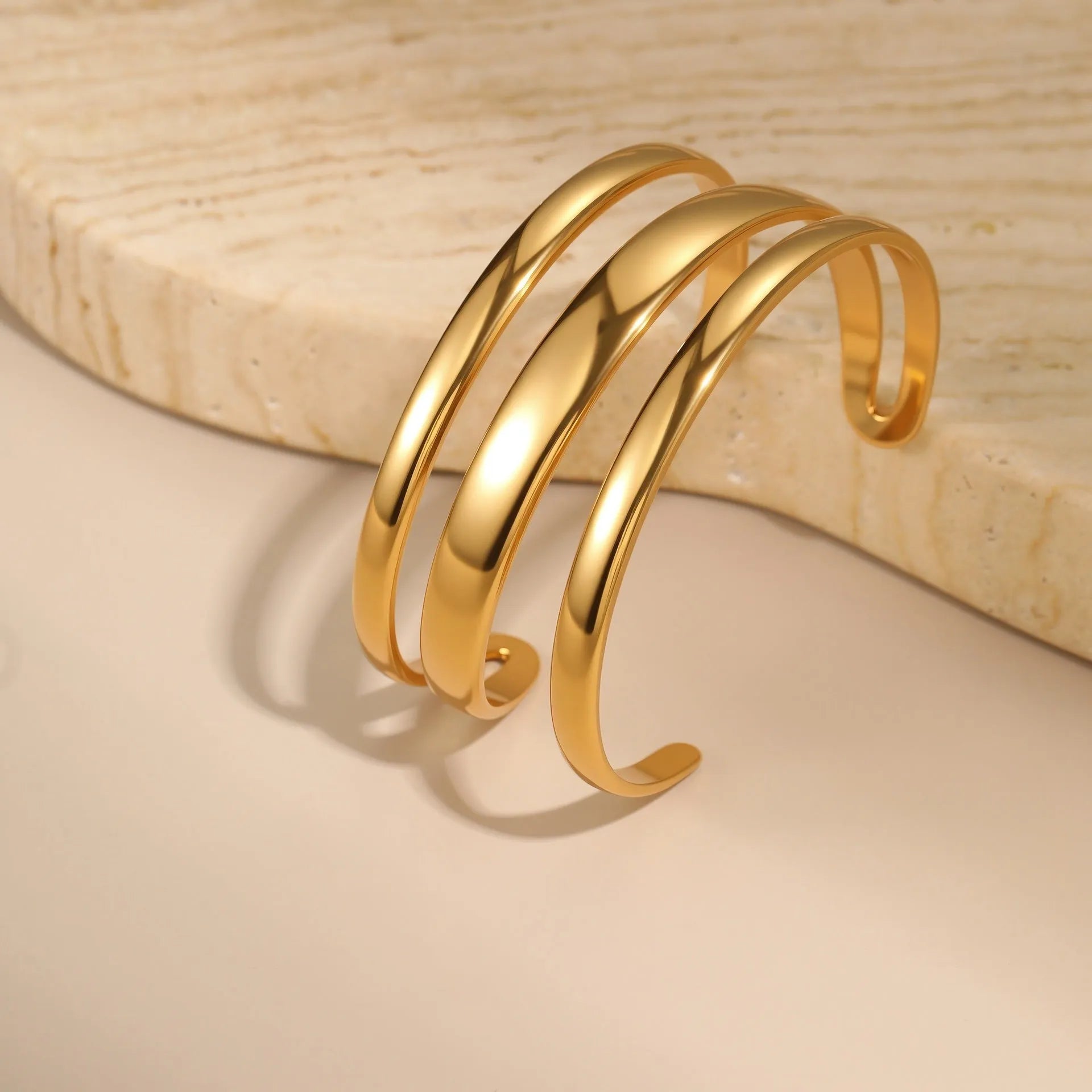 Geometric line stainless steel bracelet for women, showing gold electroplated and natural steel finish options