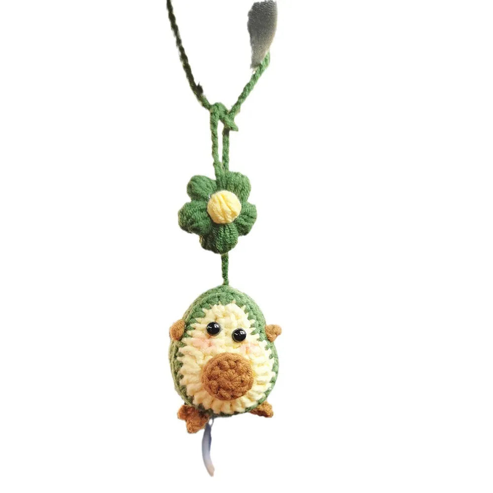 Handmade crocheted car pendant featuring a colourful avocado and rainbow flower design in wool yarn.