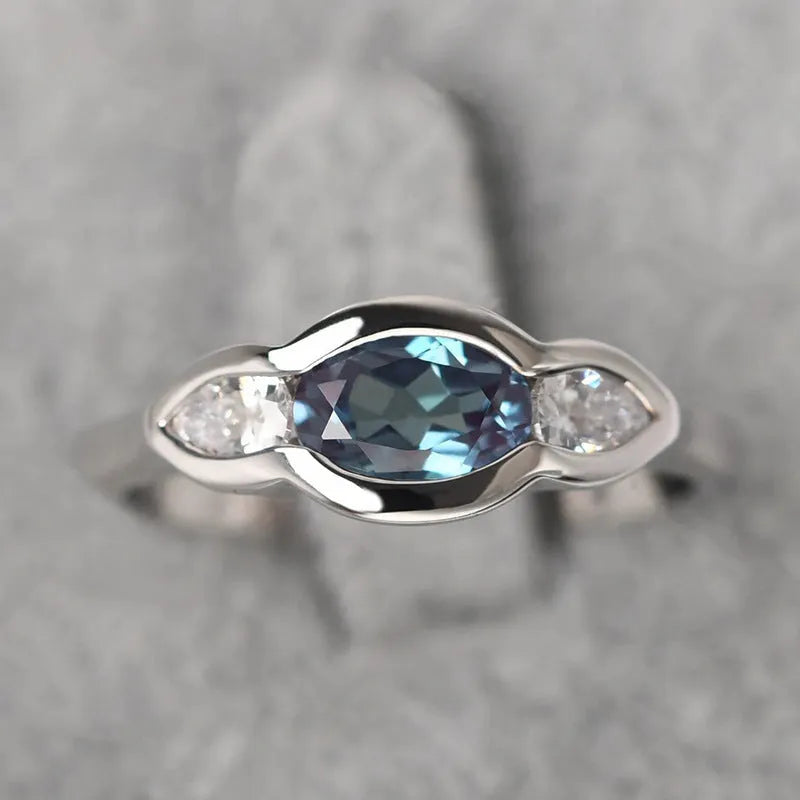Geometric ellipse-shaped women's ring with zircon inlay in a white gold finish, shown on a hand.