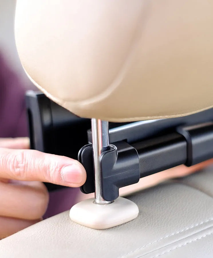 Black car phone holder mounted on vehicle rear seat base with tablet secured in adjustable grip