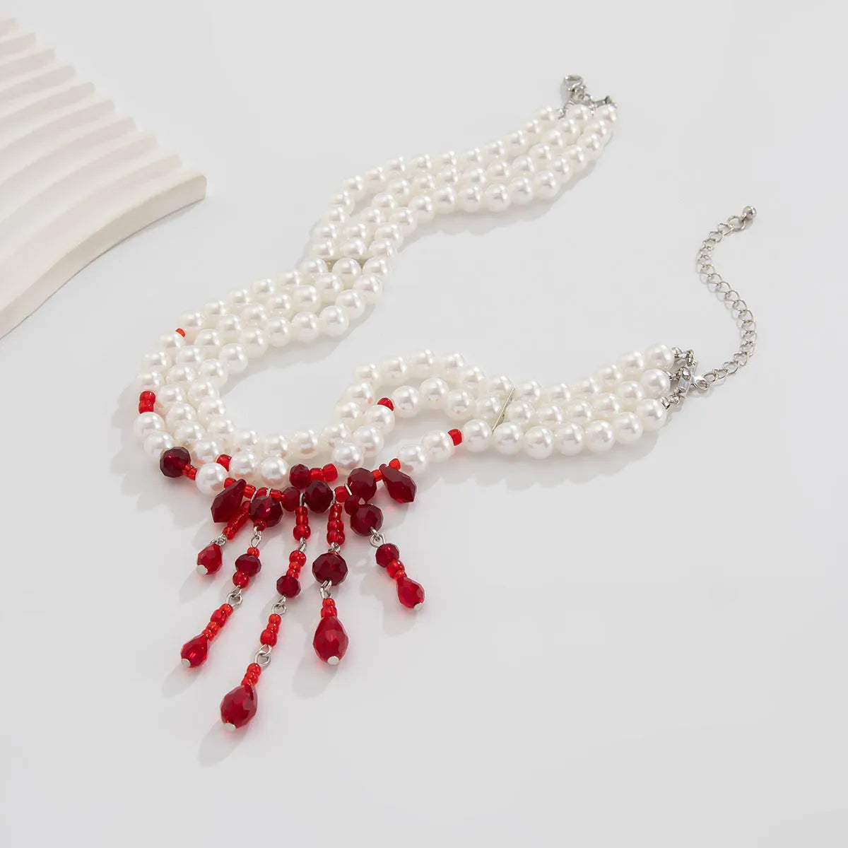 Men's blood drop tassel necklace with geometric crystal pendant and imitation pearls on a chain.