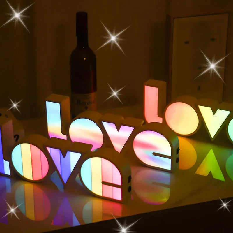 LED LOVE light with rainbow shade measuring 35.5cm, glowing softly on a wooden desk for Valentine's decoration.