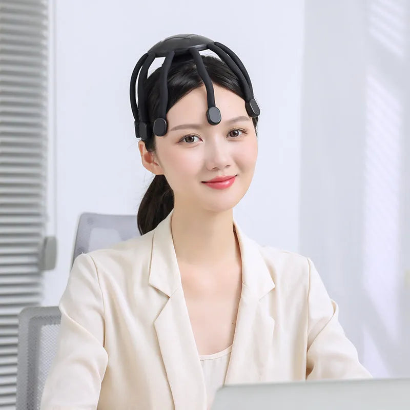 Black and white head massager with multiple claws and USB charging port showing four vibration mode settings