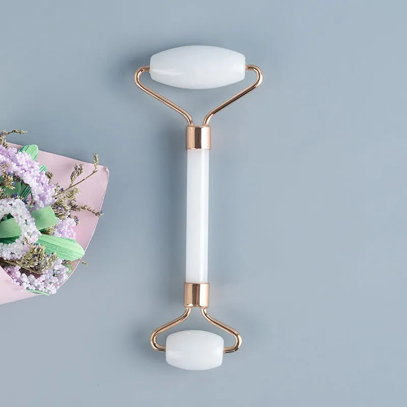 Natural white jade facial roller and gua sha scraping board set on a white background.
