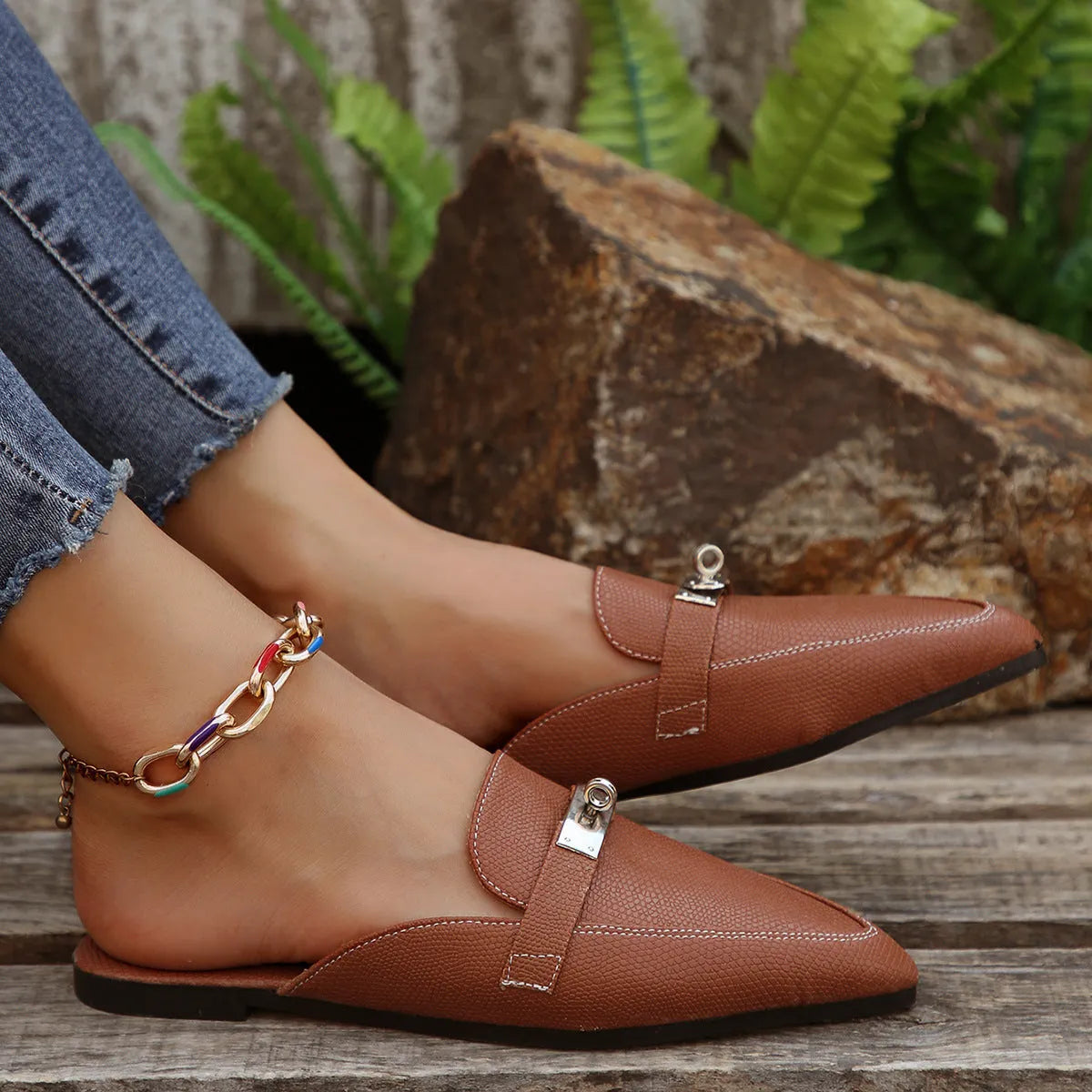 Light brown women's pointed-toe slippers with low heel design on white background