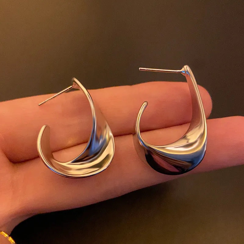 Twisted geometric metal earrings with circular elements in gold or silver electroplated finish
