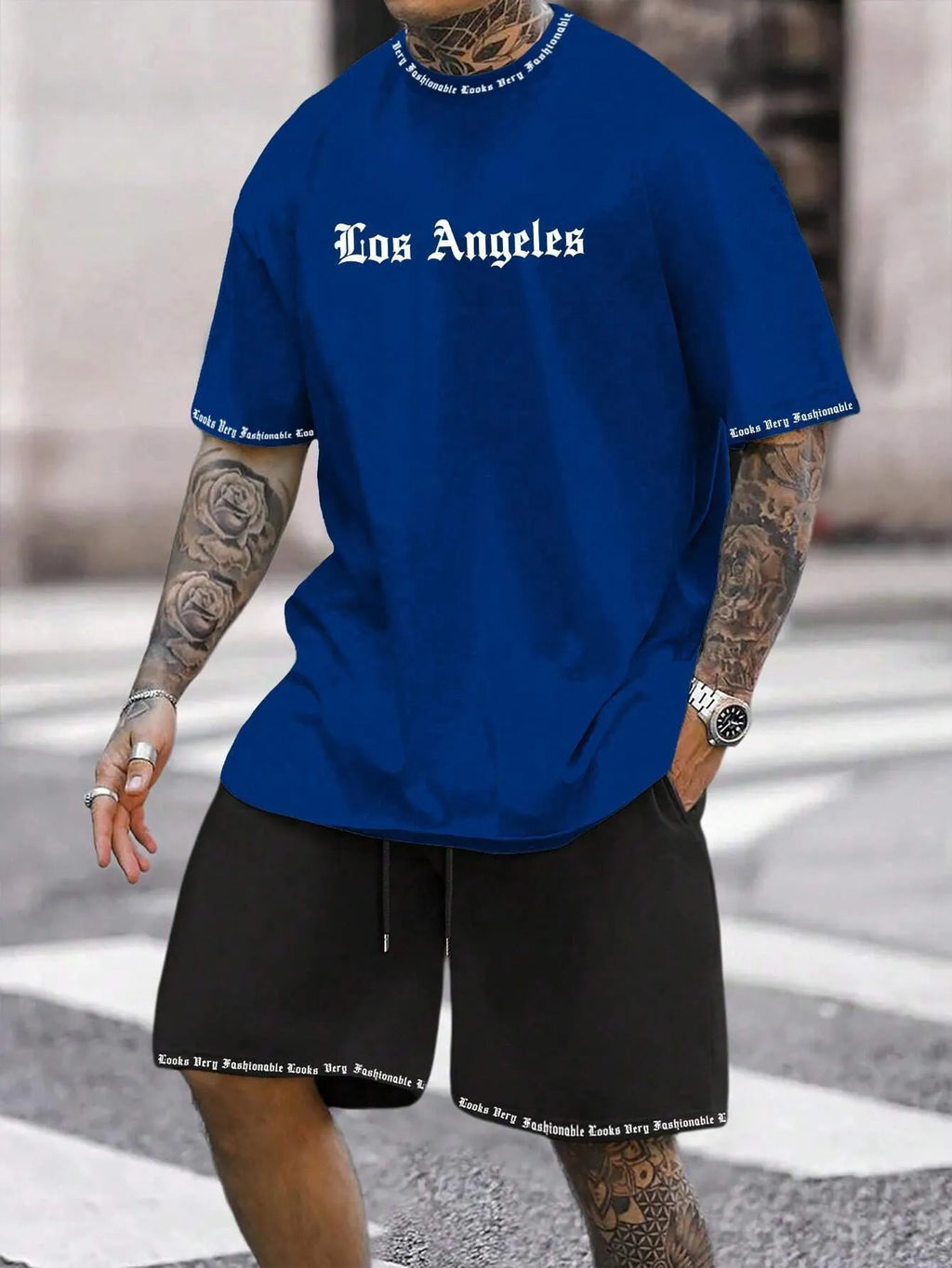 Man wearing a grey short sleeve athletic top and matching shorts from a polyester sportswear set.