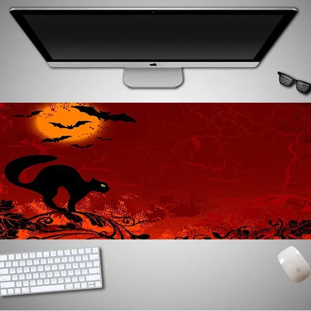 Oversized Halloween-themed gaming mouse pad on a desk, showing non-slip rubber cloth base.