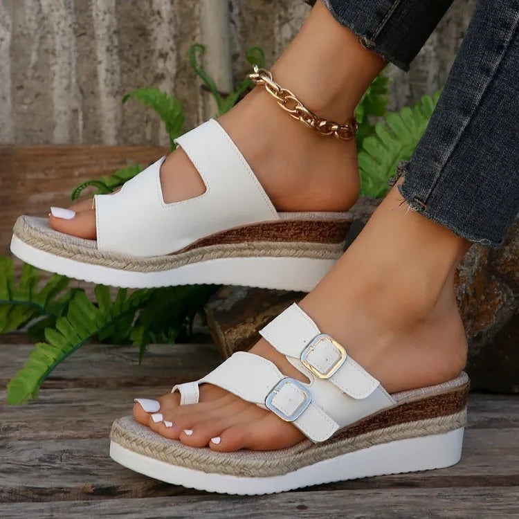 White woven patent leather women's wedge sandals with peep toe and finger-fit design on a neutral background.