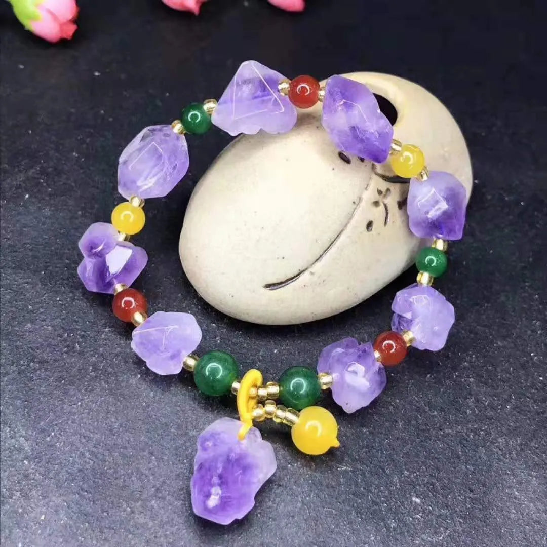 Natural shaped amethyst bead bracelet with a fu character charm on a white background
