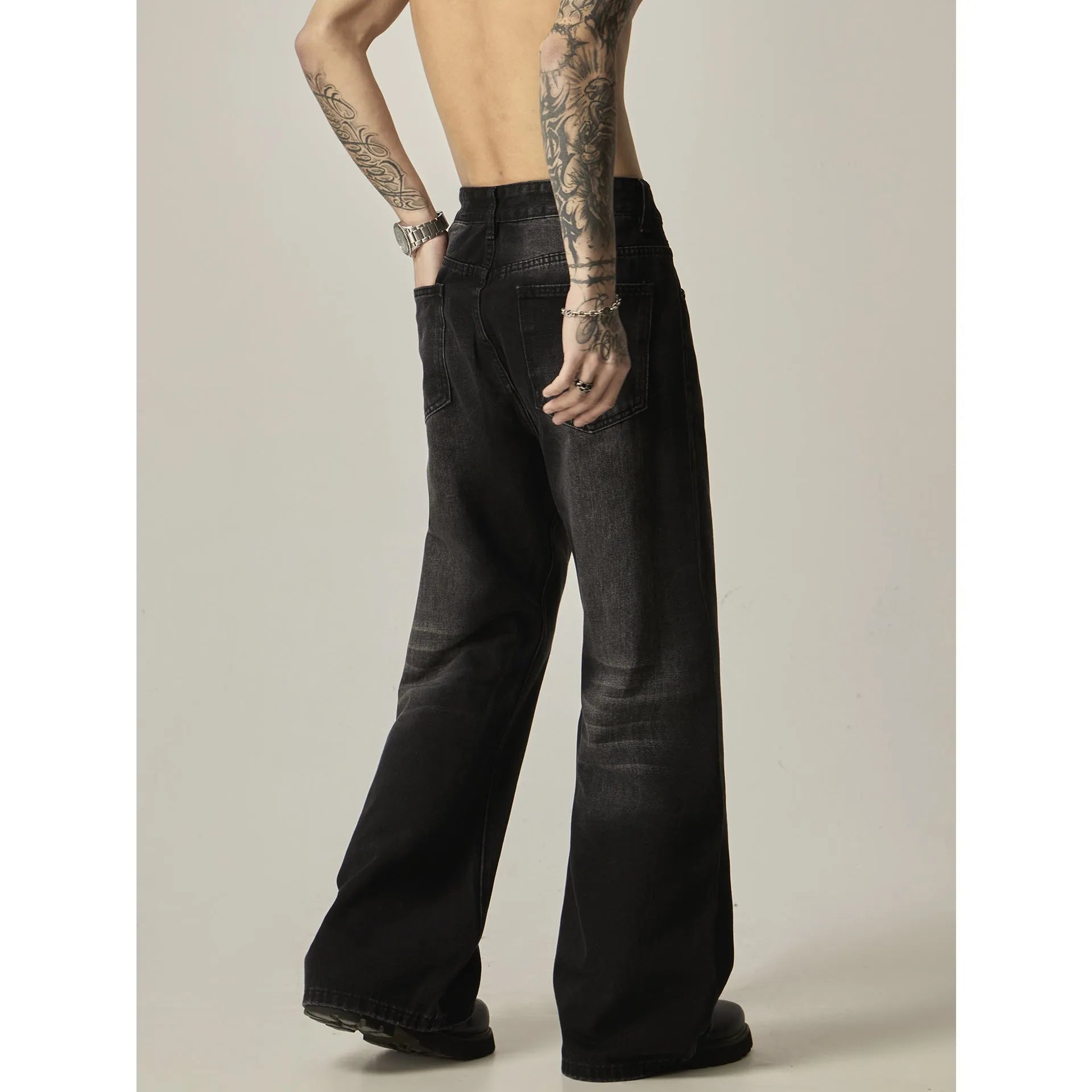 Black loose straight jeans with retro styling and zipper fly on mannequin